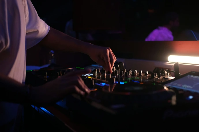 Dj hands adjusting controls on a sound mixer
